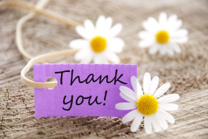 a purple label with Thank you on it and flowers in the background ** Note: Slight blurriness, best at smaller sizes